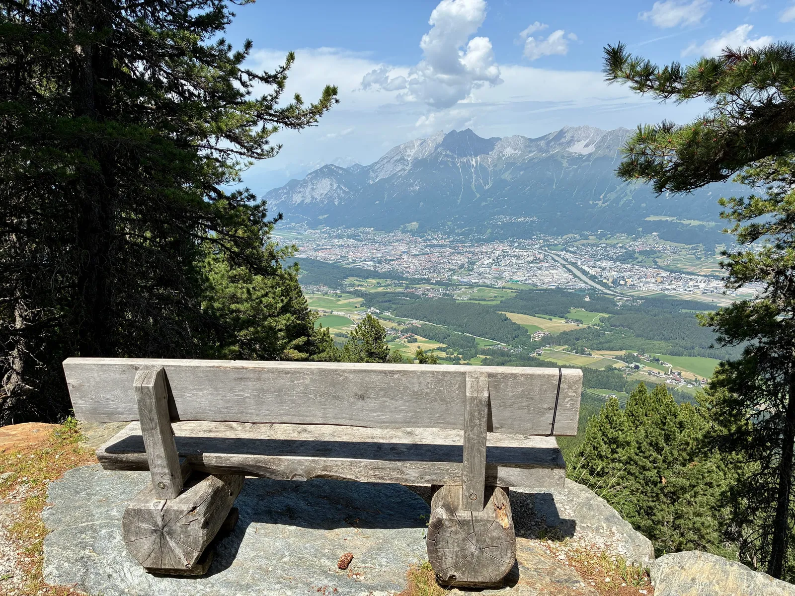 Holzbank an einem Aussichtspunkt mit Blick über das Inntal auf Innsbruck